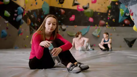 Teenage girl drinking water in a climbing gym