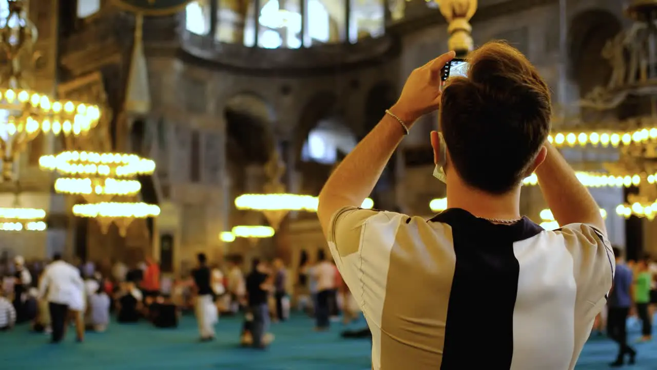 Close Up Shot of Young Man Taking Pictures Inside Hagia Sophia