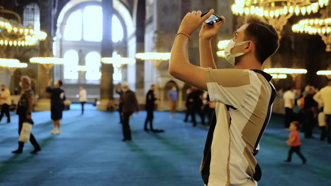 Medium Shot of Young Man Taking Pictures Inside Hagia Sophia