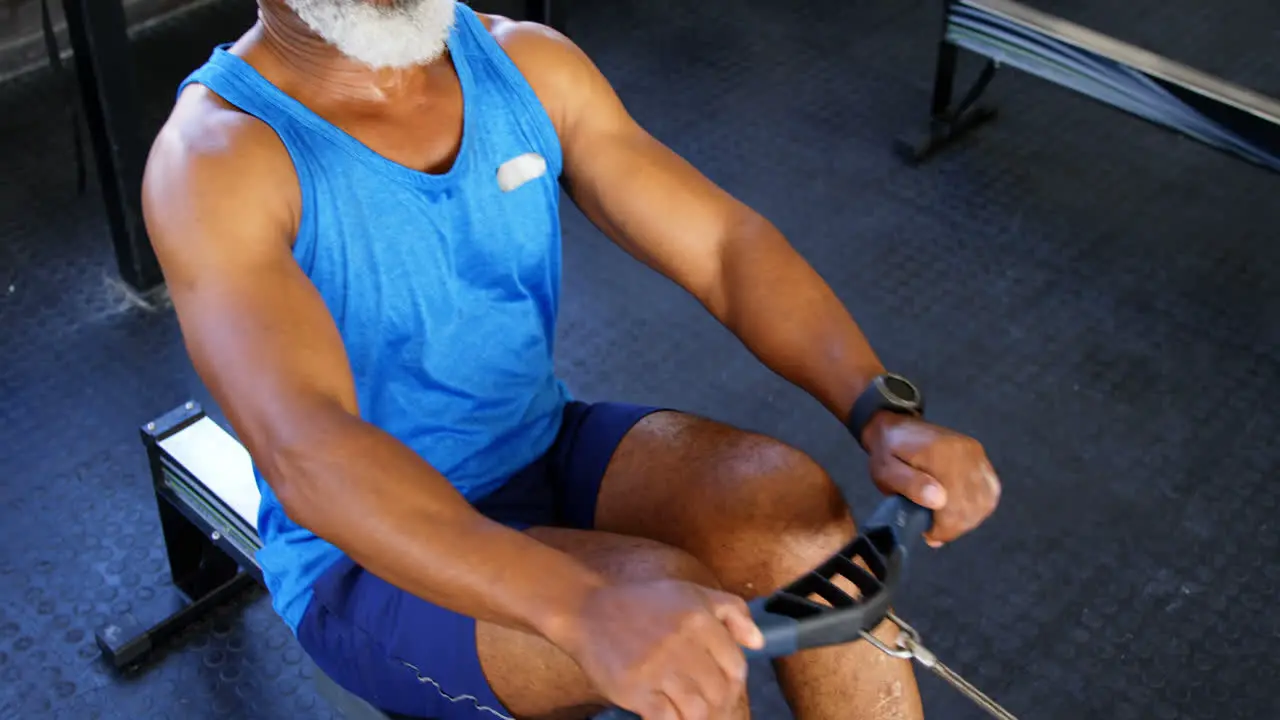 Senior man working out on rowing machine 4k