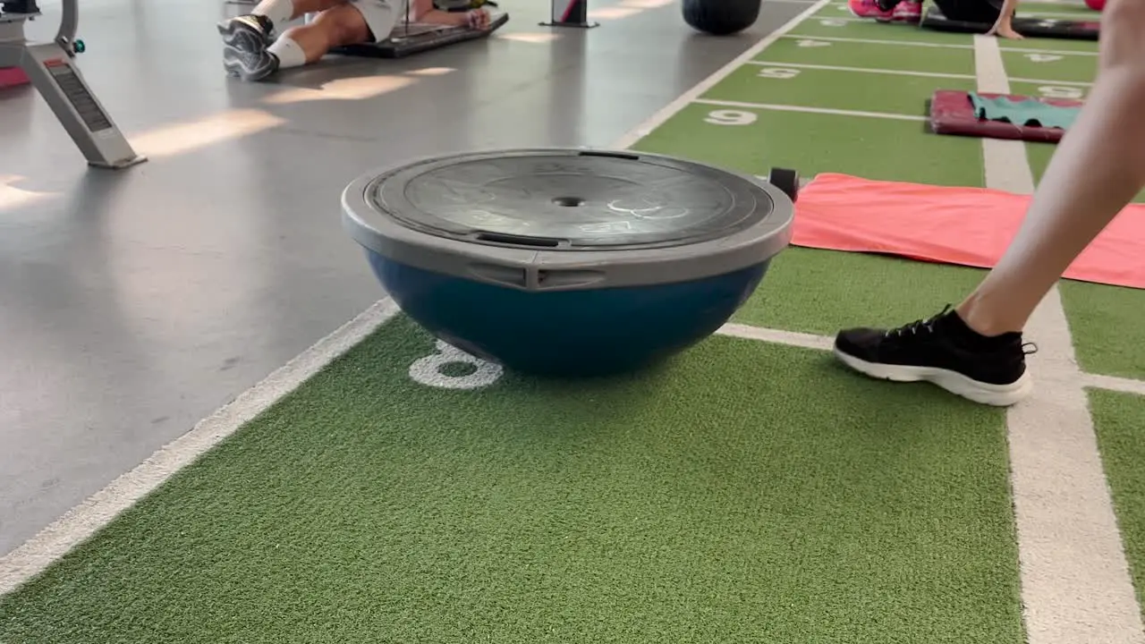 Young Caucasian woman doing push ups from fitness ball while training in gym indoors