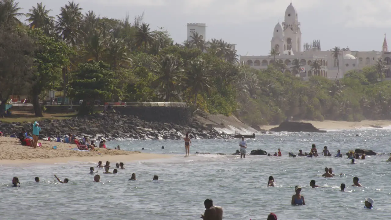 Beachgoers relaxing in sunshine and swimming in sea at Belneario beach San Juan Puerto Rico