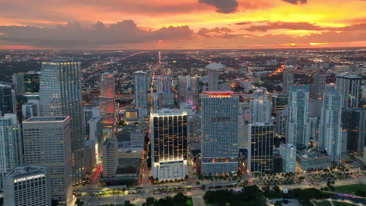 Miami sparkles at evening presenting a dynamic aerial view with landmark buildings and avenue traffic