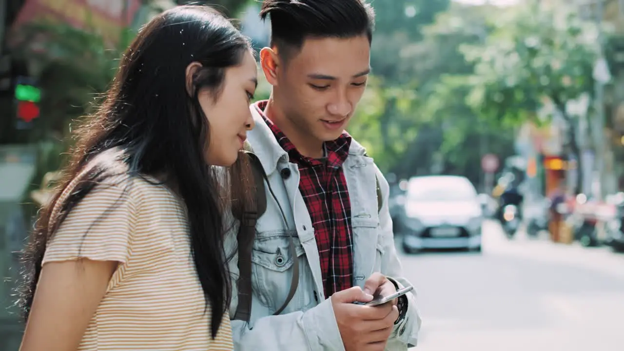 Handheld view of Vietnamese couple looking at mobile phone