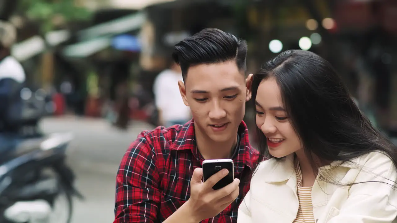 Handheld view of Vietnamese couple making a selfie