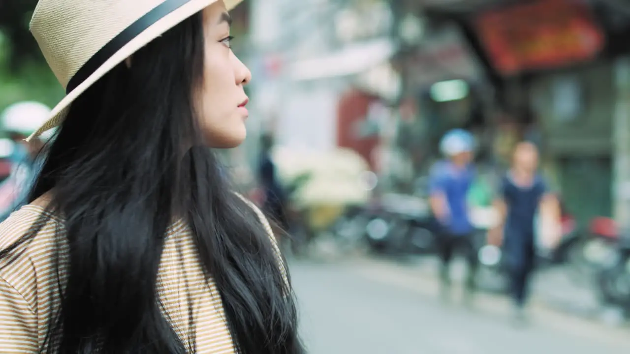 Handheld view of Vietnamese woman with mobile phone waiting for taxi