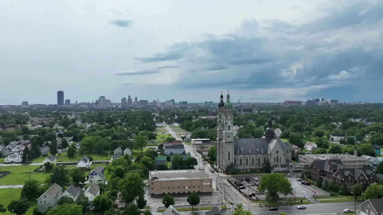 An rising aerial view of the green city of Buffalo New York with storm clouds in the distance