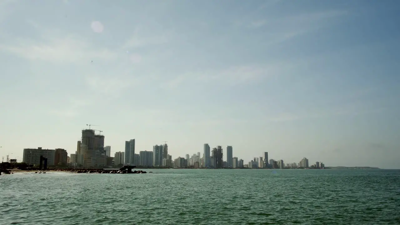 Sea by Cartagena with distant skyscrapers on clear day