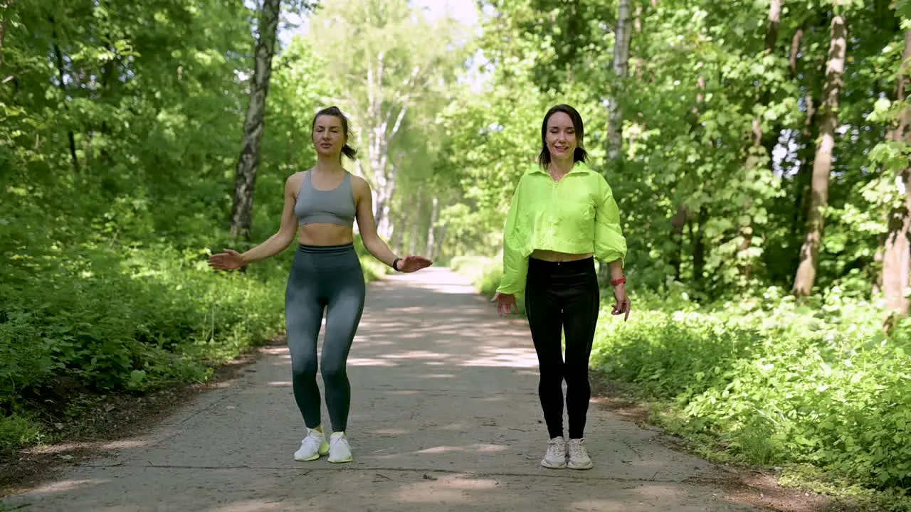 Fit Women Doing Jumping Jacks In The Park