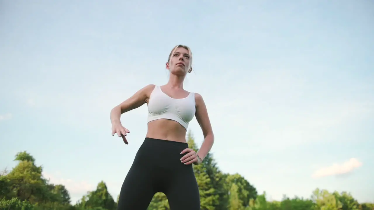 Beautiful Blonde Fitness Girl Doing Side Bend Exercises Outdoors In The Park