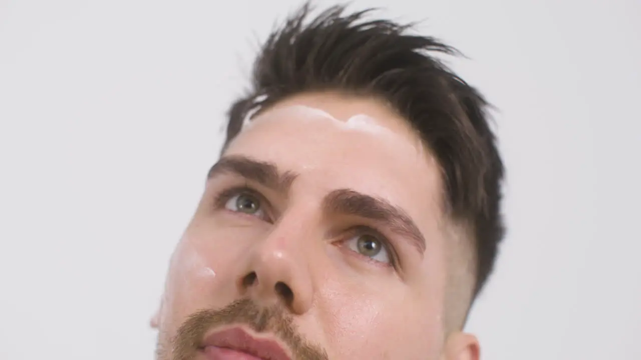 Good Looking Green Eyed Man Applying Moisturizer To His Face