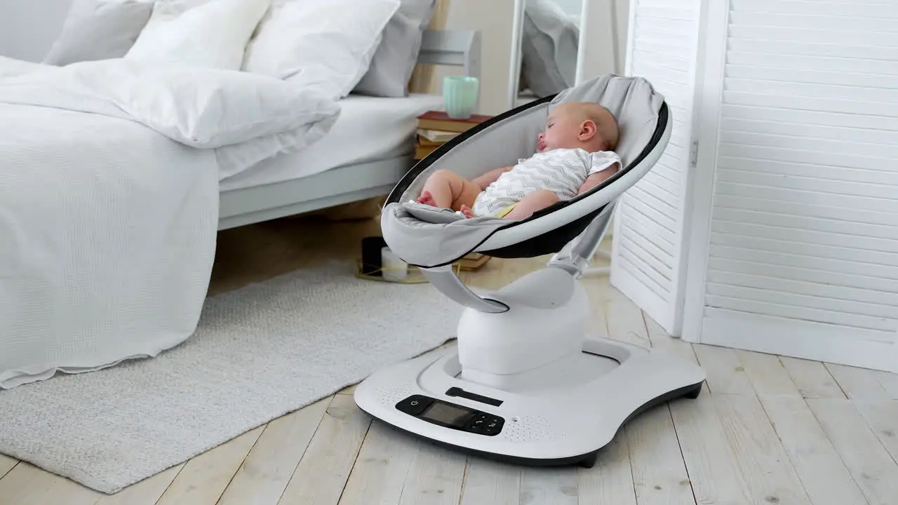 Baby sleeps in a rocking chair for children high-tech design in white bedroom