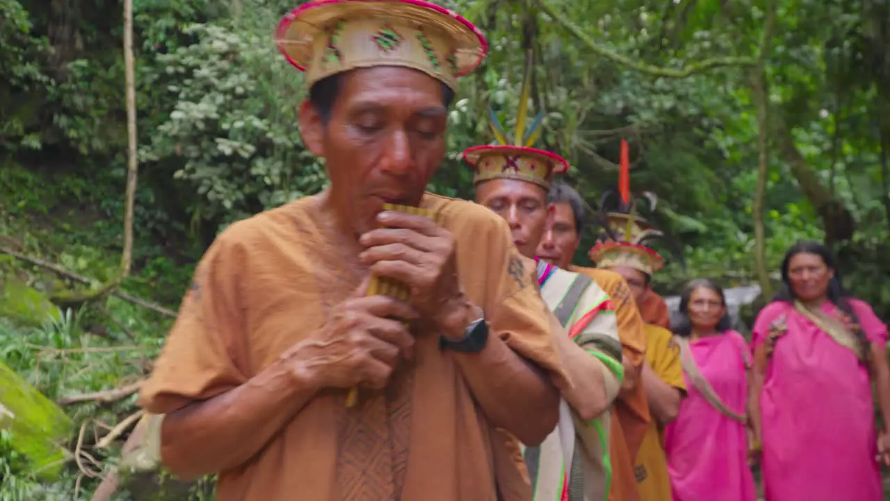 Indigenous men playing flute with group of women in traditional dress Oxapampa Peru daytime cultural ceremony