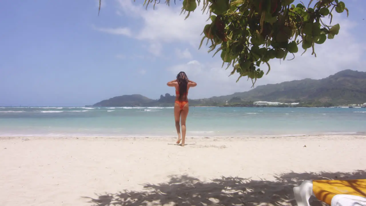 Latin Girl in Bikini on Hot White Sandy Beach Walks to Swim in Sea Gentle Zoom in