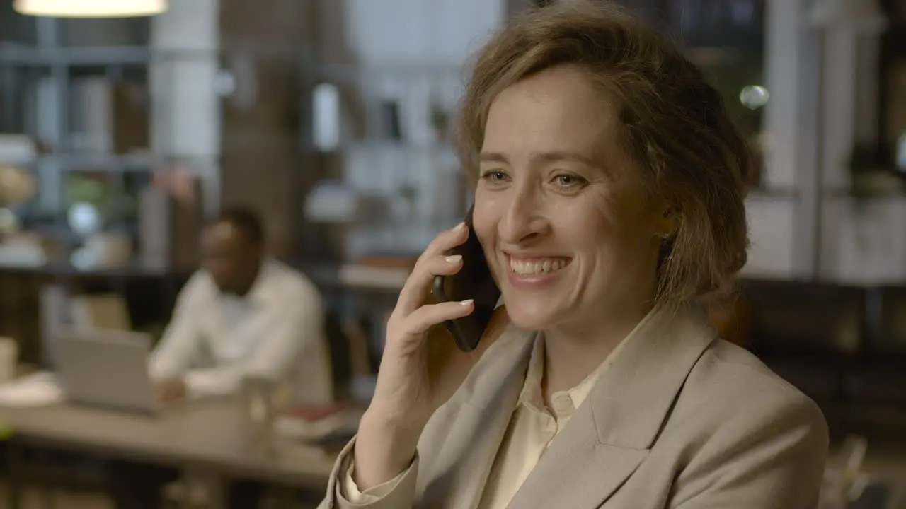 Retrato De Una Mujer De Negocios Sonriente Hablando Por Teléfono Móvil Mientras Está De Pie En La Oficina