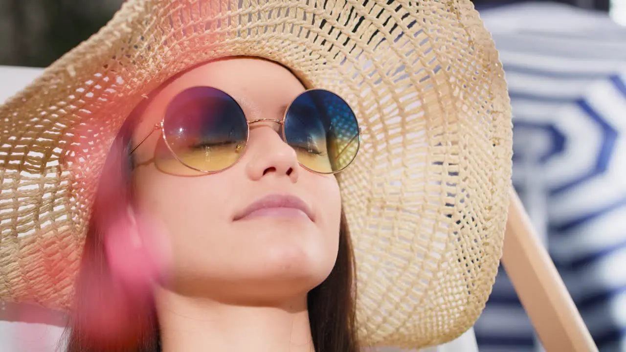 Close up video of woman in sunglasses relaxing on the beach