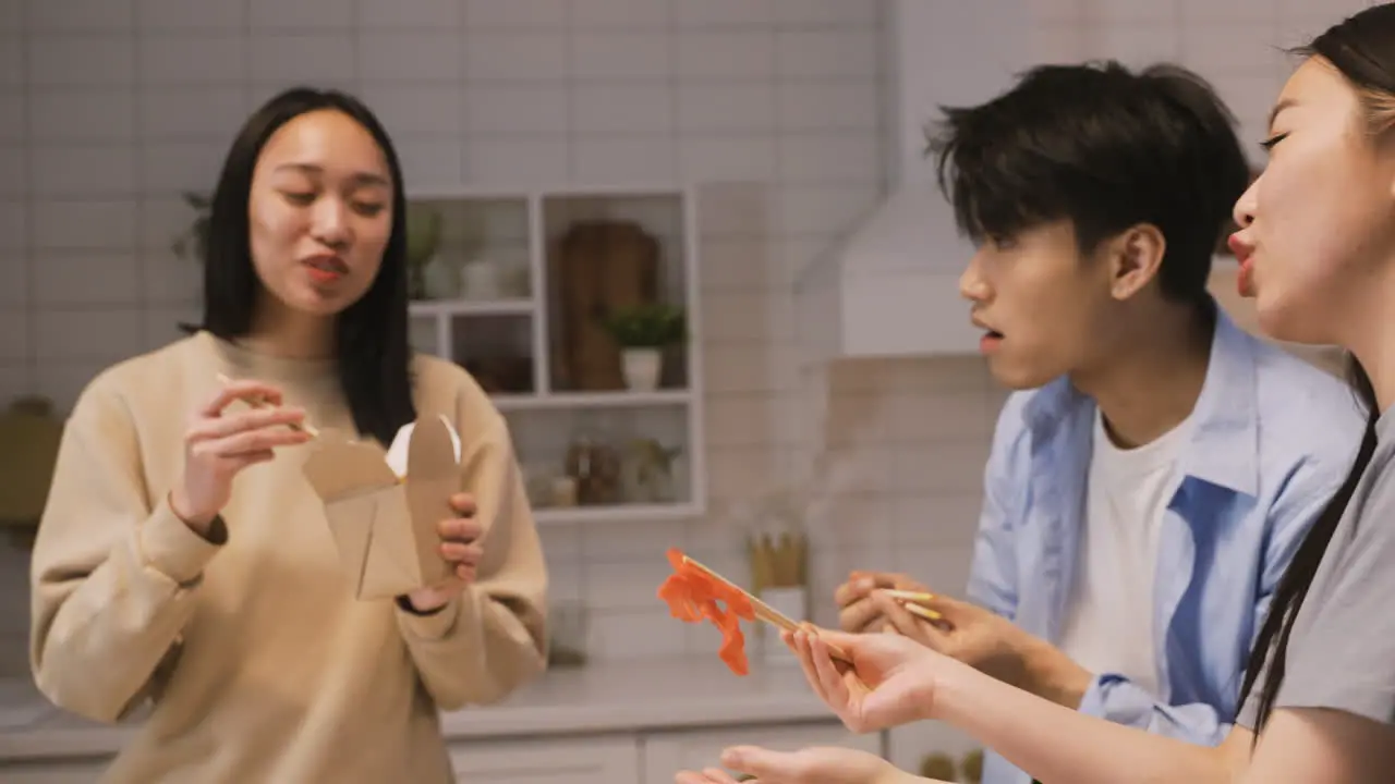 Tres Amigos Japoneses Sentados Alrededor Del Mostrador De La Cocina Y Comiendo Comida Japonesa