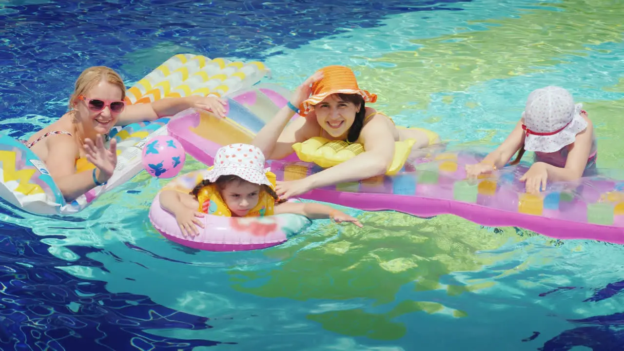 Happy Parents With Children Are Swimming In The Pool Hold On To An Air Mattress Look At The Camera 4