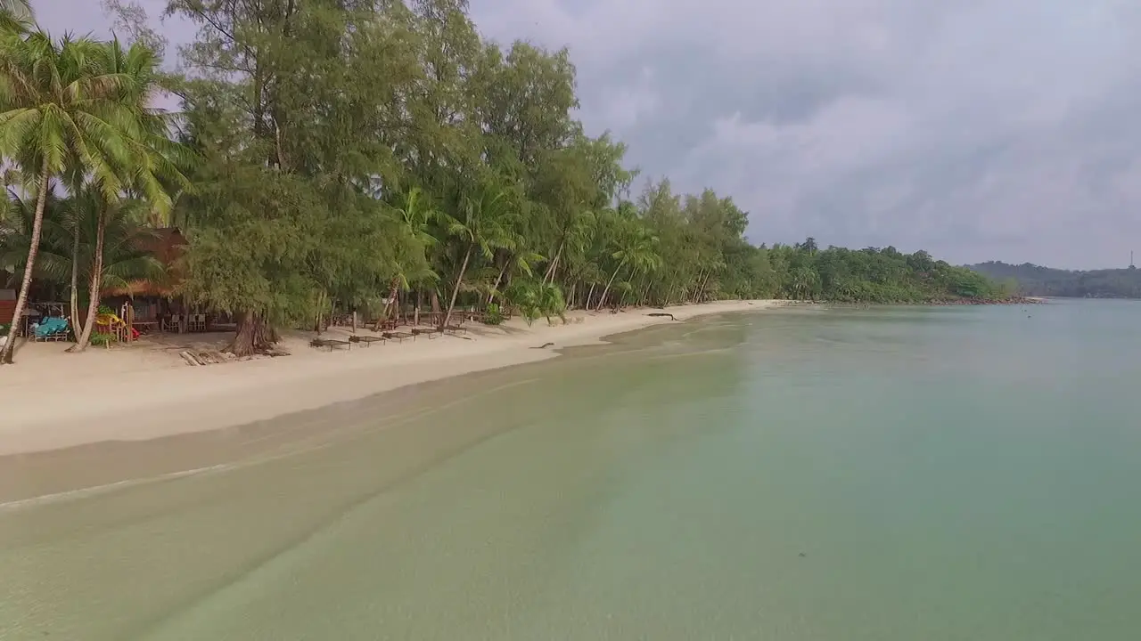 Aerial drone dolly shot of a beach on a tropical Thai island with resort and clear ocean in Koh Kood