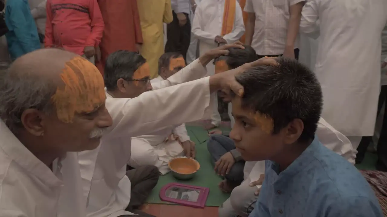 A group of Indian priest applies holy tilak made with sandalwood on the forehead of people during Ram Rath procession on the occasion of yearly celebration of Ram Navmi