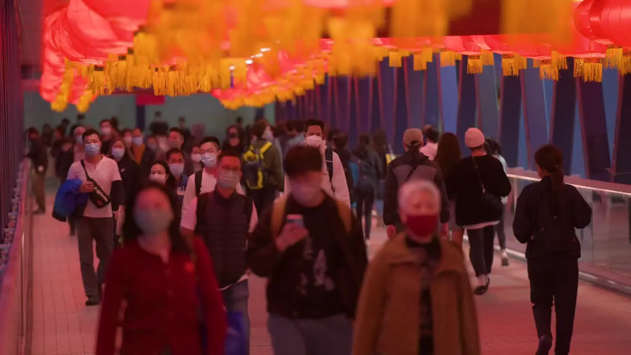 Chinese commuters walk through a pedestrian bridge decorated with Chinese red lanterns hanging from the ceiling to celebrate the Chinese Lunar New Year festival in Hong Kong