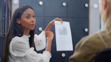 Over the Shoulder of Woman Discussing Document with Colleagues 