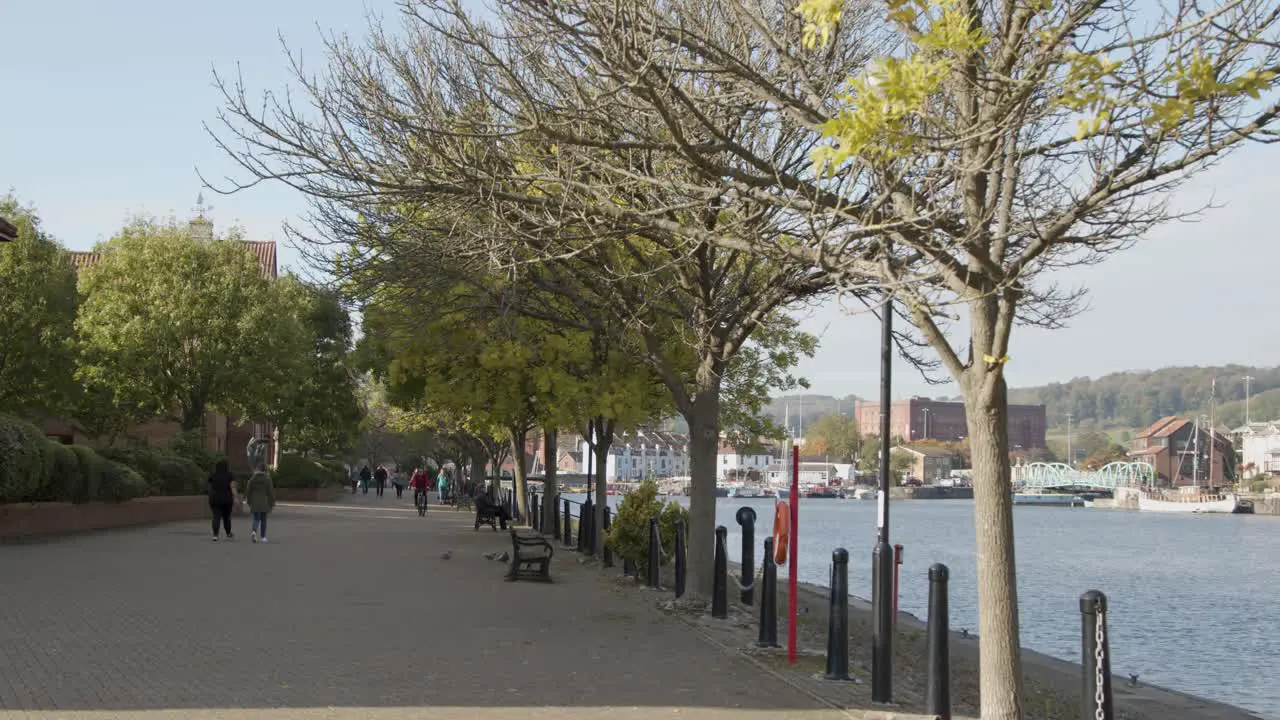 Tracking Shot Along Busy Waterside Pathway In Bristol England