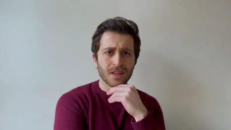 Young Male University Student Looking Visibly Concerned While Talking to Camera On Video Call