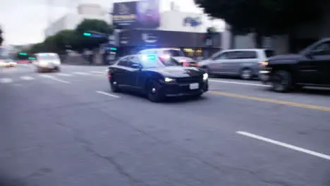 Hollywood Police Vehicles with Flashing Siren Driving Past