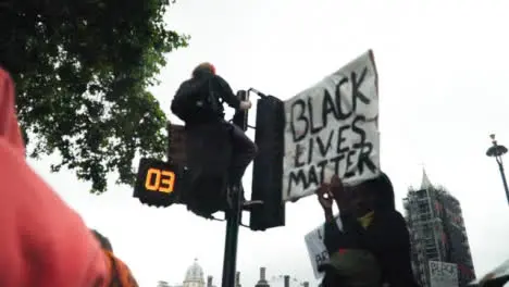 London Protestor Sits On Traffic Light During Black Lives Matter Demonstrations