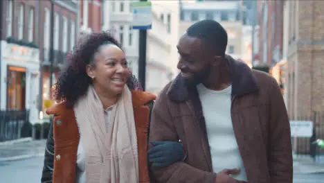 Couple Walking Arm In Arm Through Street On Winter Visit To London 2