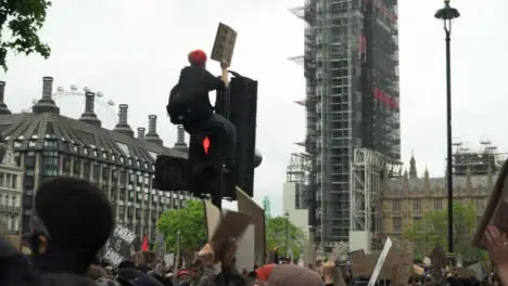 London Black Lives Matter Protester Sitting On Traffic Light