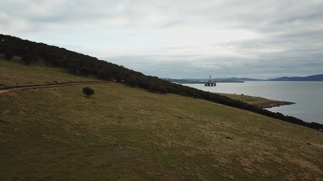 Drone PAN Over Coastal Foreshore With Oil Rig In Background Australia