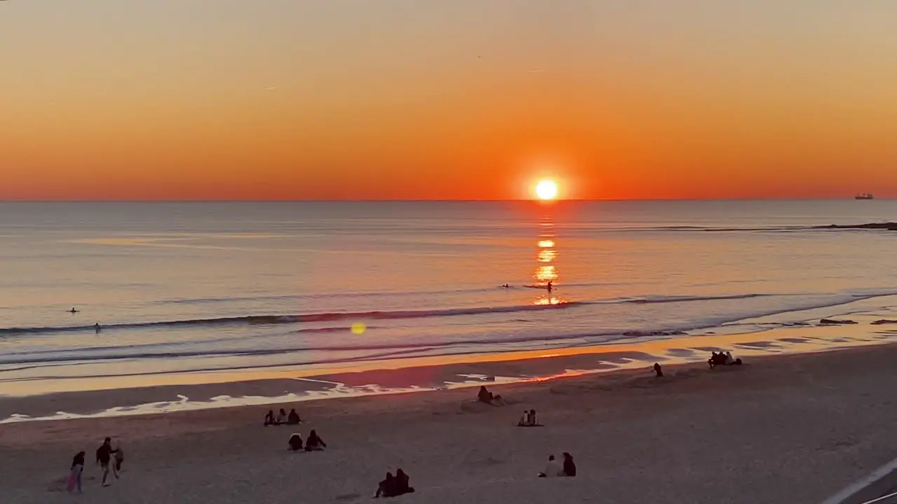 People enjoying the sunset on the beach in cascais Portugal