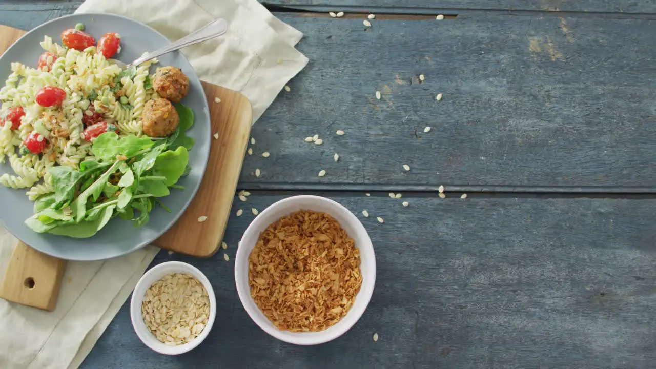 Video of fresh salad with green leaves and bowls with seeds on wooden background