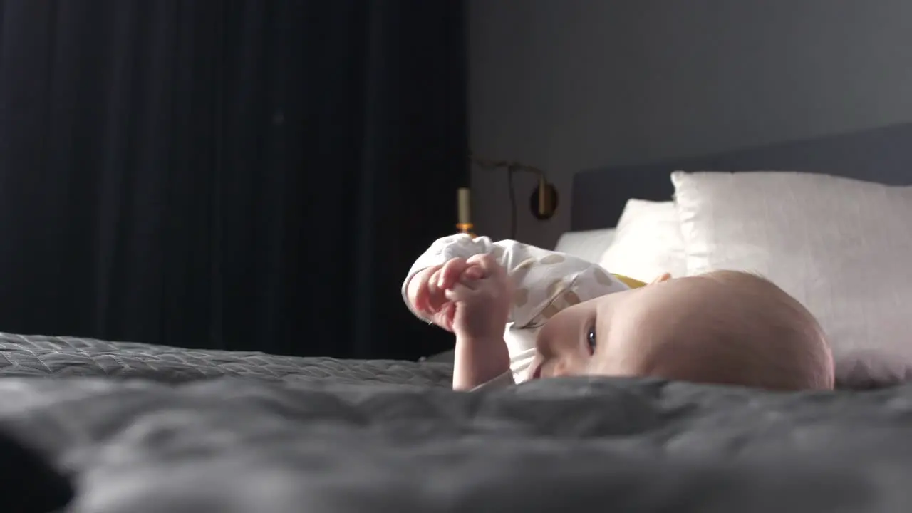 Caucasian newborn baby rolling on bed