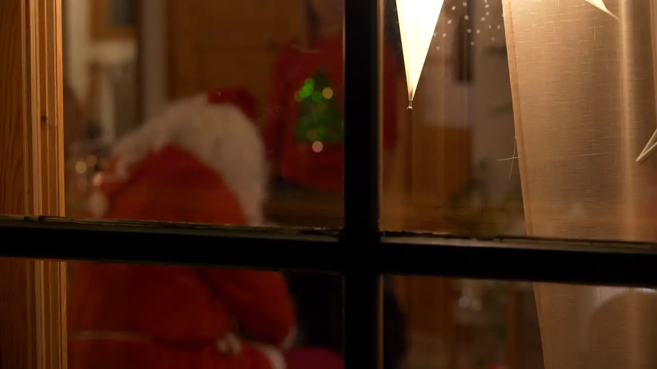 Santa Claus visit on Christmas Eve-handing out X-mas presents to children shot through window