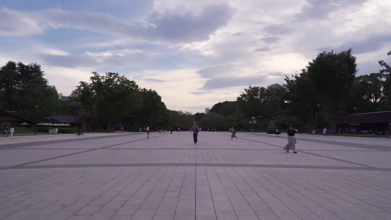 Wide open view of Ueno Park square at cloudy dusk with people walking