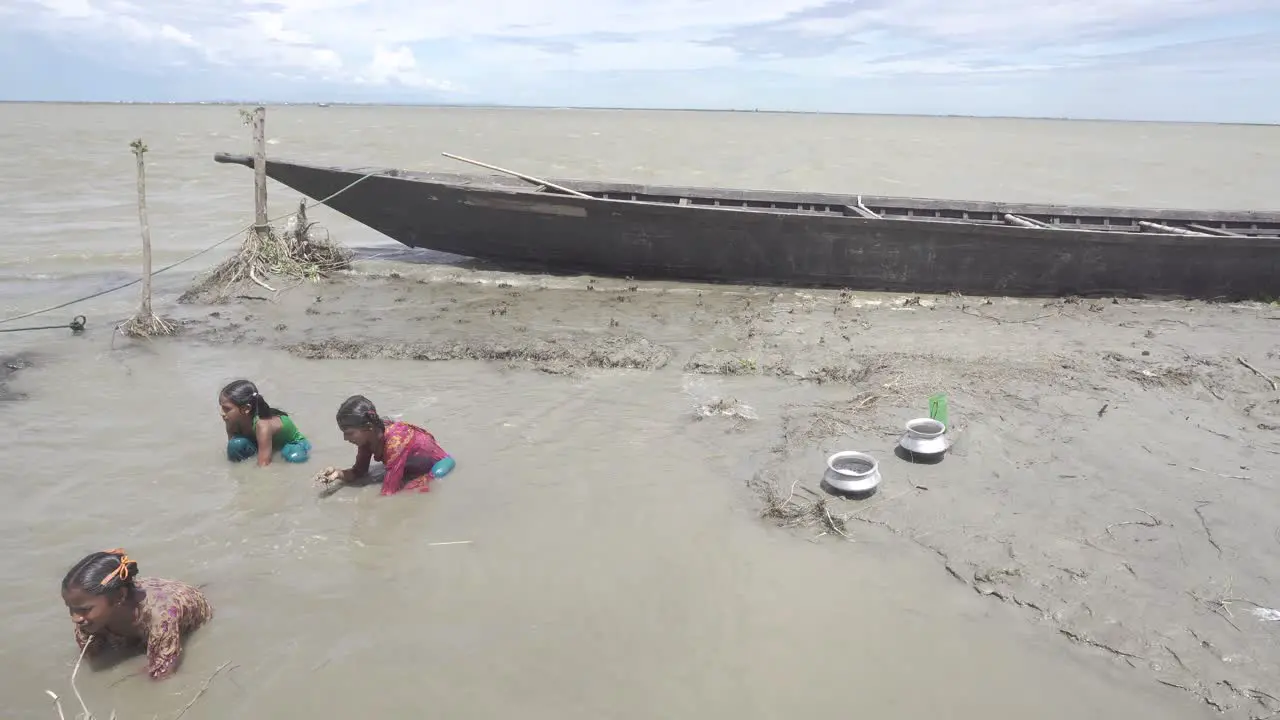 Children trying to catch fish from trapped river water