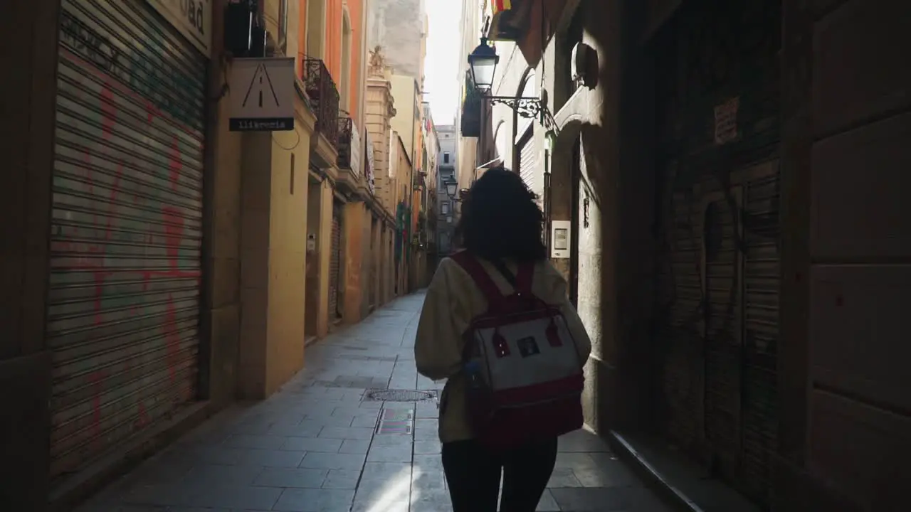 Medium Moving Shot Woman Holding a Camera while Walking on the Streets of Barcelona Spain Bright Sunny Day in the background