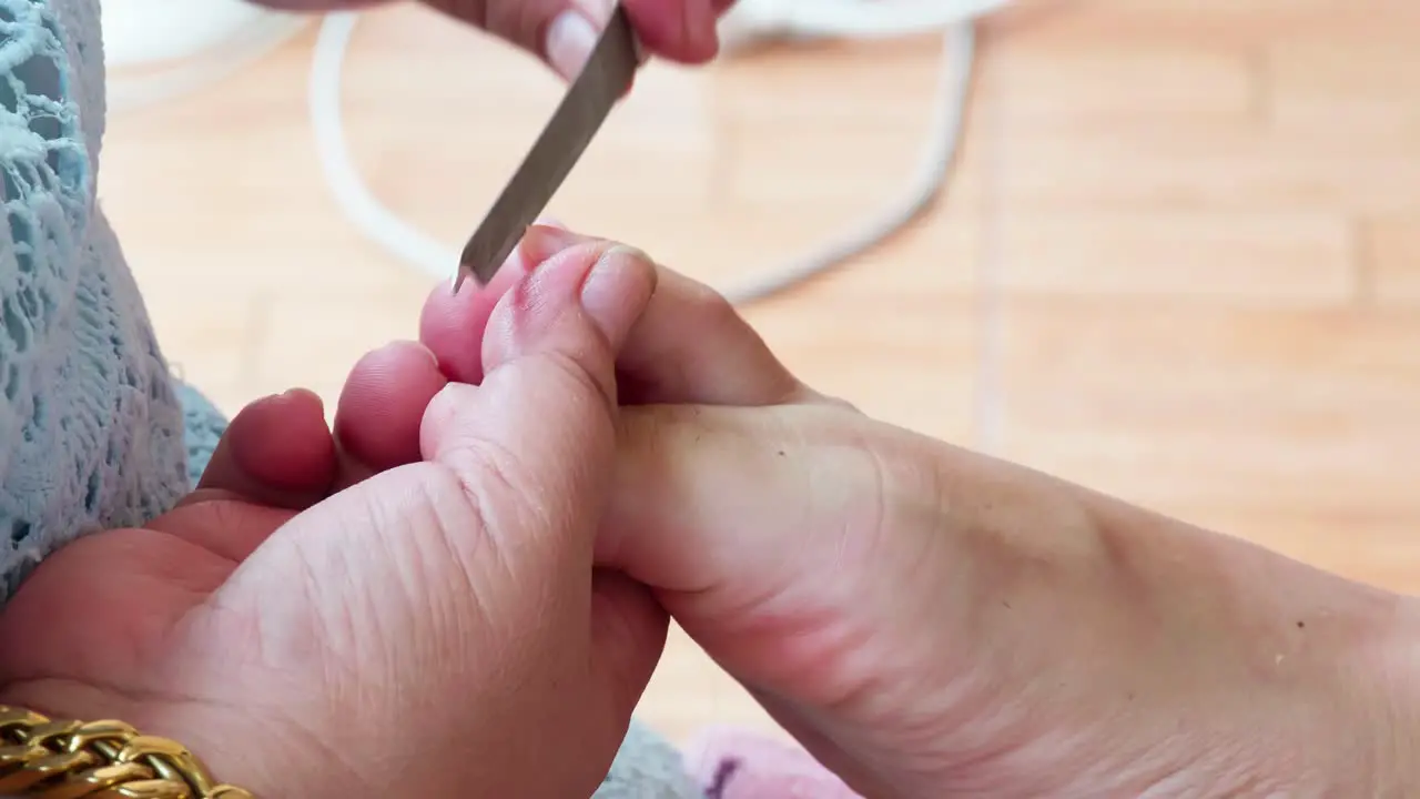 Pedicurist master making pedicure cutting cuticle with nail