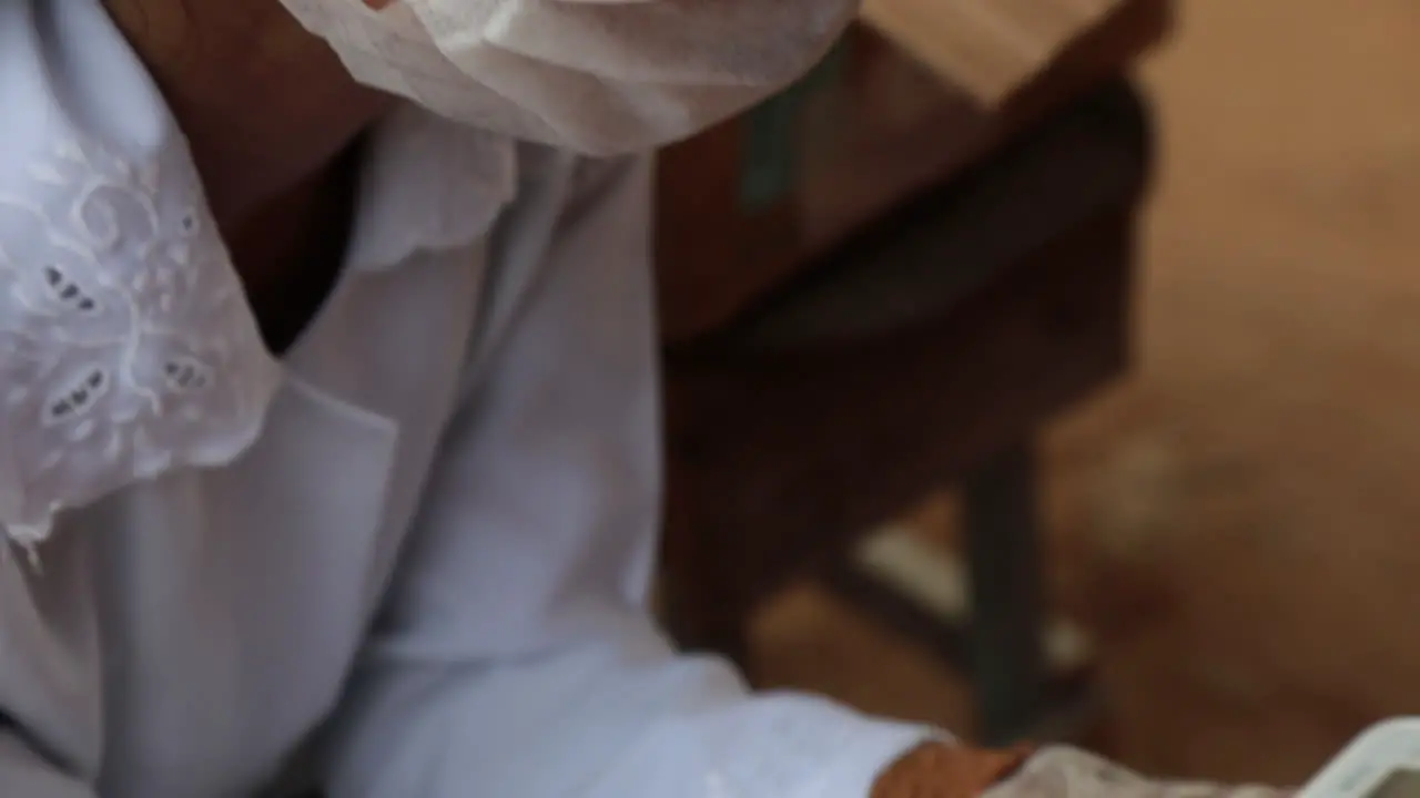 Close up shot of a tribal healer volunteering as a COVID-19 nurse inspecting a digital thermometer