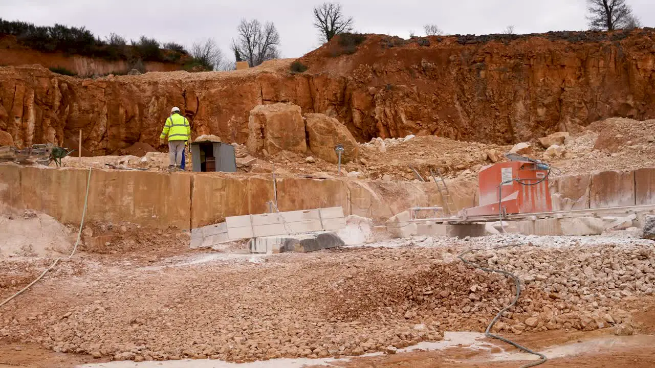 Limestone quarry mine with cut blocks being inspected by crew Pan right shot