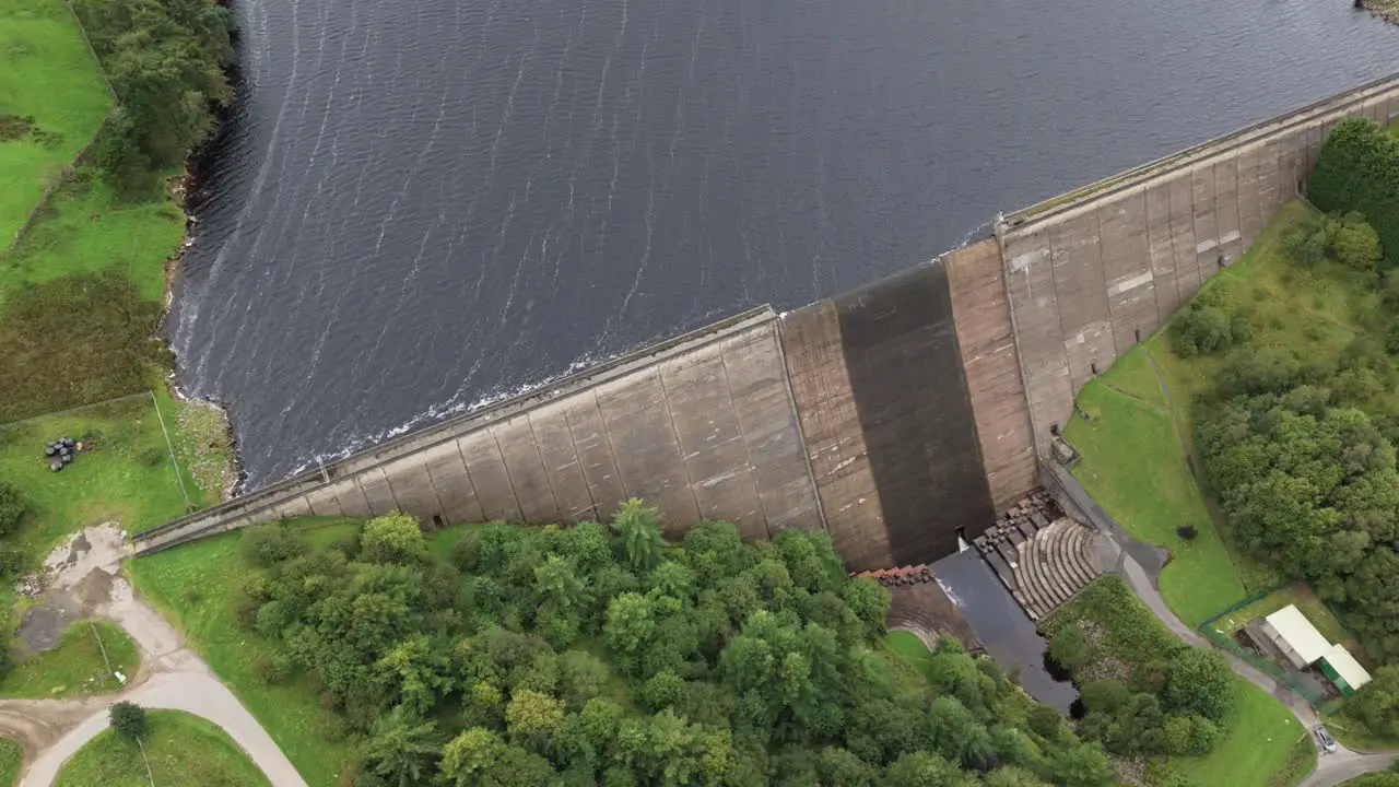 Booth wood reservoir aerial view looking down circling fresh water lake and concrete dam spillway West Yorkshire