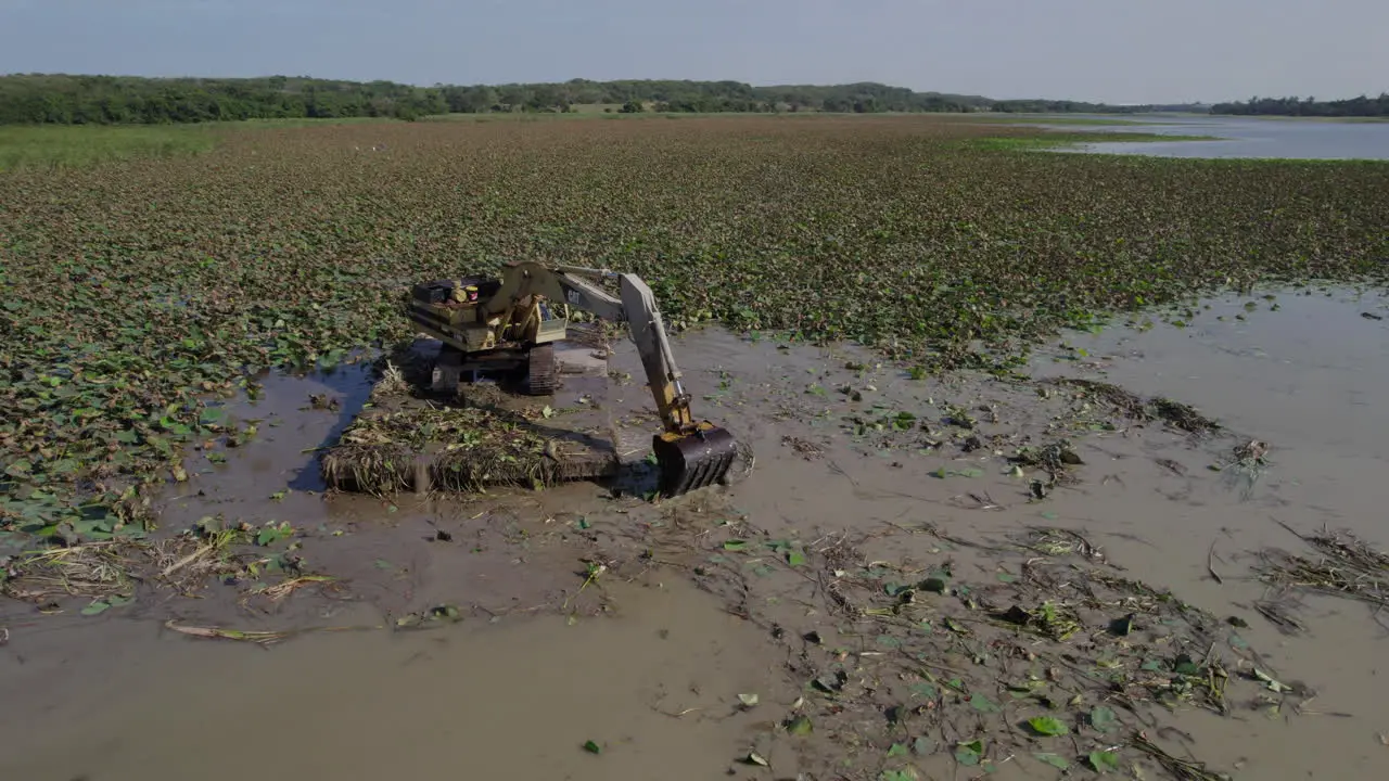 A robust excavator meticulously clears a swamp on a marine platform