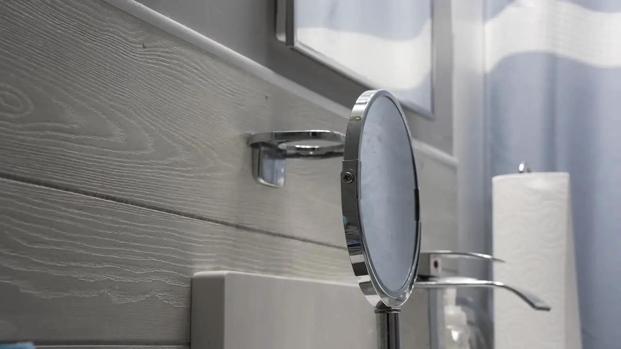 A man grabs his green toothbrush from its holder in a bathroom