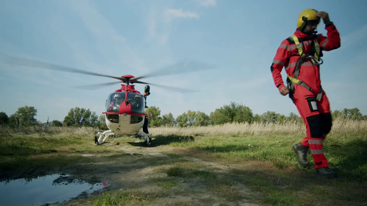 Helicopter Rescuer walking from landed Helicopter sunny day wide shot slowmotion