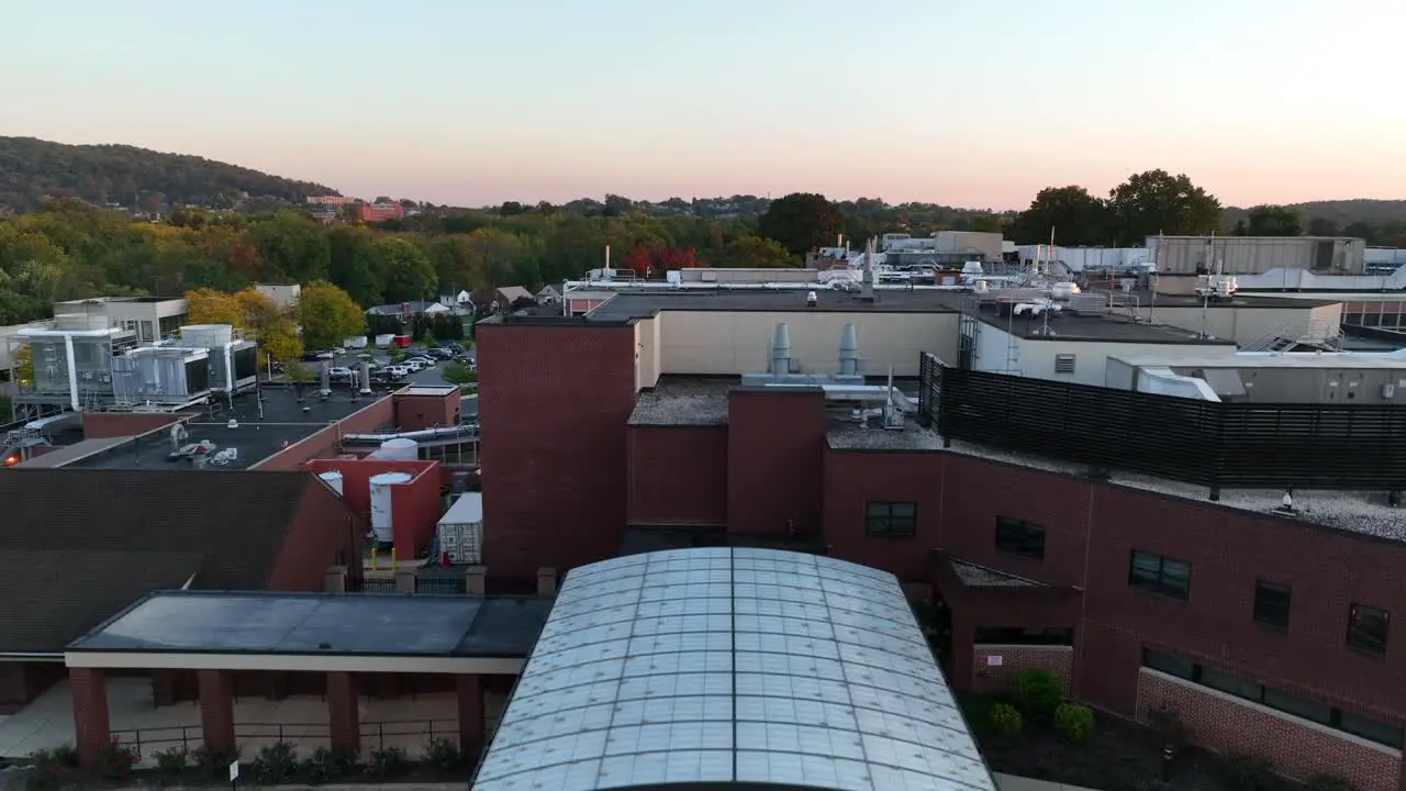 Rising aerial shot features emergency room and hospital at sunrise