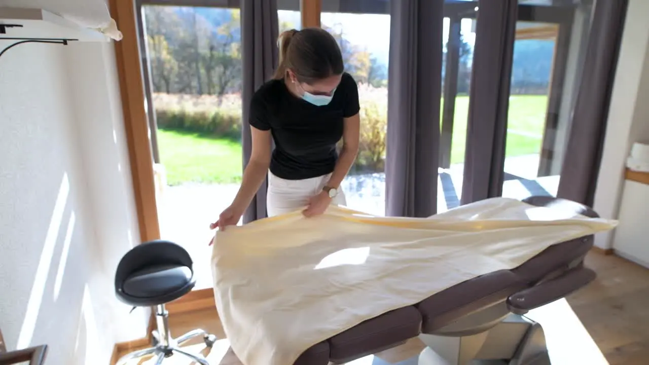 Masseuse with face mask prepares massage in the wellness center