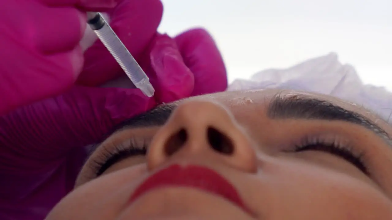 Latina woman getting Botox injections near her eye